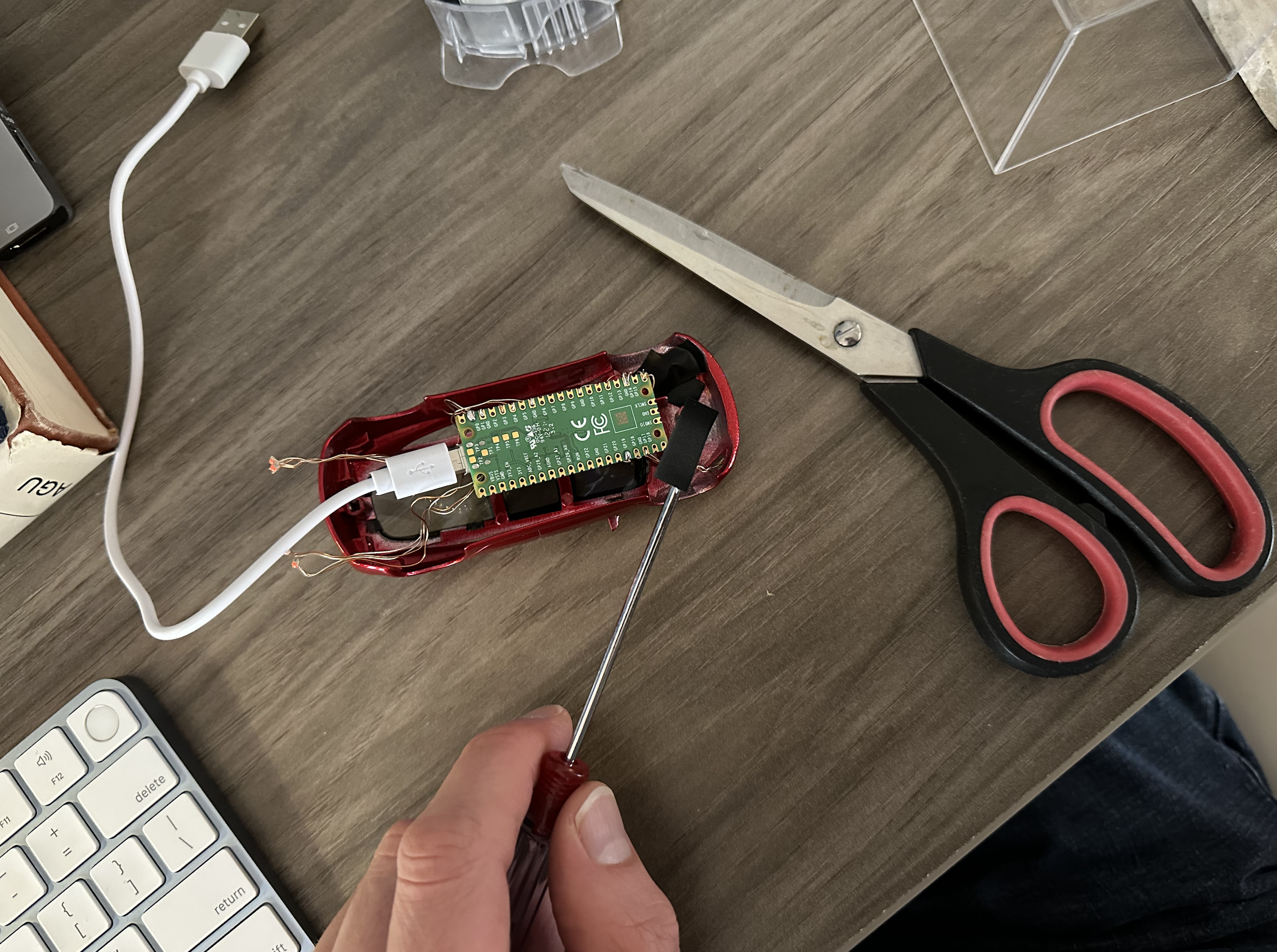 Tiny Tesla model car with LED lights being installed using electrical tape to hold them in place